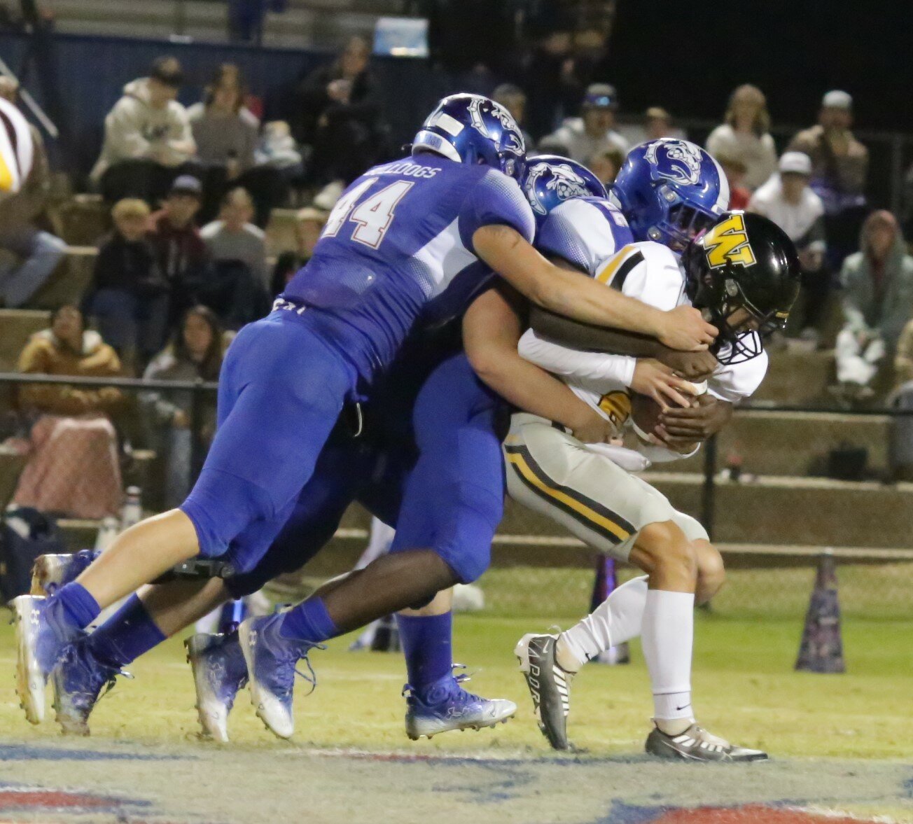 Landon Green, Michael Hipp and Devon Robertson overwhelm a Winona ball-carrier in Quitman’s victory Friday.